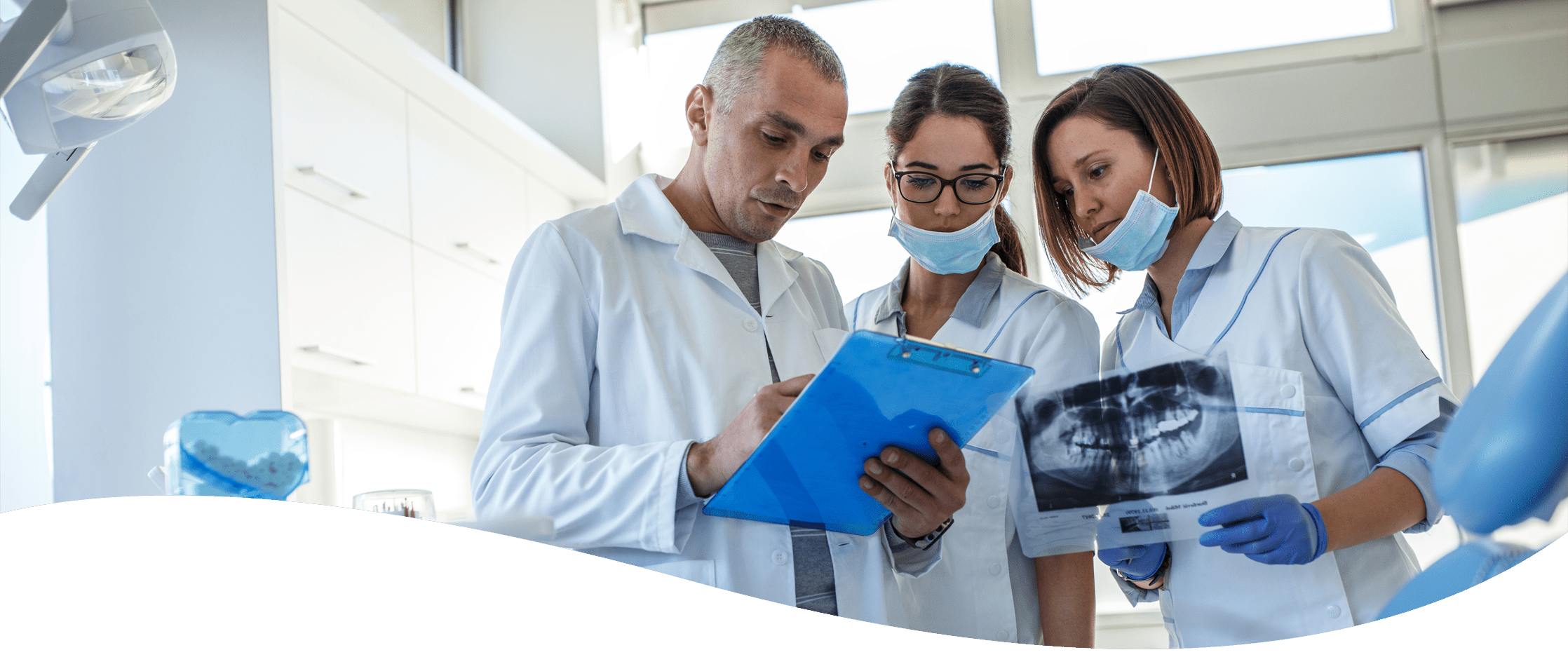 Group of dentists looking at x rays in a dental office